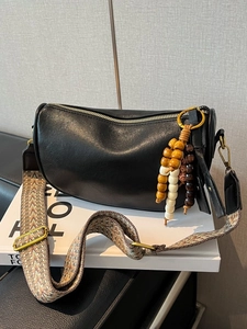 Chic black leather Boston bag with wide bohemian strap and ethnic wooden bead charm