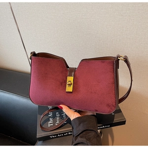 Détail du sac seau bordeaux en daim avec fermoir rotatif en métal doré vintage