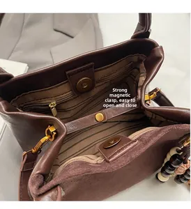 Detail des Magnetverschlusses und gestreiften Stofffutters im Lederbeuteltasche