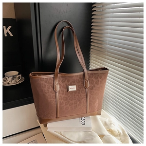 Détail du sac cabas léopard avec écusson logo dans un décor de style de vie