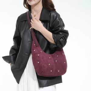Dettaglio borsa hobo in camoscio bordeaux con borchie dorate e tracolla regolabile fine