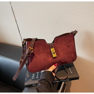 Détail du sac seau bordeaux en cuir mat avec un fermoir rotatif doré de style rétro