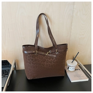 Détail du sac cabas léopard avec anses en cuir marron et boucle en métal doré