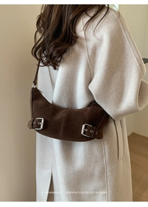 Mannequin portant un sac croissant en daim marron foncé avec boucle rétro