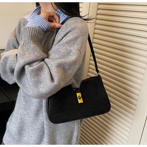 Détail du sac hobo en daim noir mat avec fermoir rotatif doré et fine bandoulière