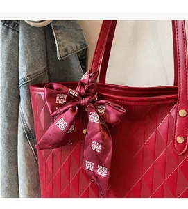 Detail of red quilted tote bag featuring a wedding silk scarf and metallic rivets