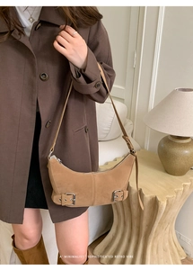 Detail view of camel suede shoulder bag with metal buckle and zipper in a retro style