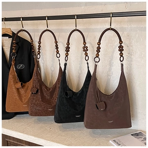 Collection of vintage suede tote bags featuring unique wooden bead handles and leopard prints