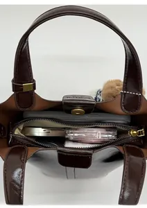 Top view showing the spacious interior of the brown bucket bag with everyday essentials