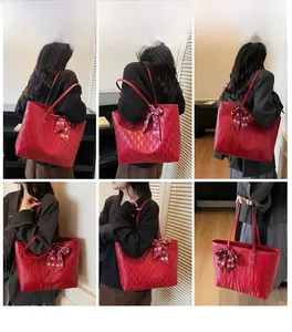 Macro details of red quilted tote bag with silk scarf accessory and glossy texture