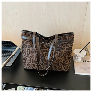 Détail du sac cabas léopard avec poignées en cuir marron et garnitures métalliques chic