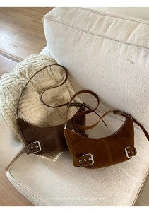 Detail of minimalist suede crescent bags featuring retro silver buckle straps and zippers