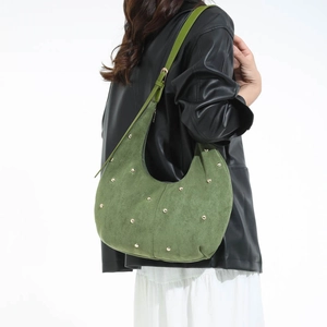Dettaglio borsa hobo in camoscio verde con borchie dorate e tracolla regolabile