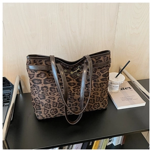 Gros plan du sac fourre-tout léopard avec lanières en cuir sur un bureau de travail