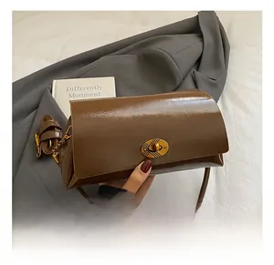 Gros plan d'un sac en cuir vintage marron avec fermoir rotatif ovale en bronze