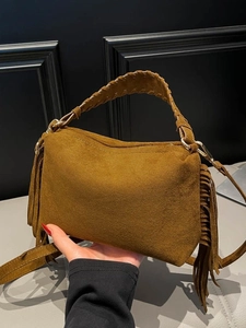 Brown faux suede crossbody bag with fringe tassels and woven handles in vintage style