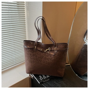 Détail d'un sac cabas léopard avec texture daim et accents de boucles en métal