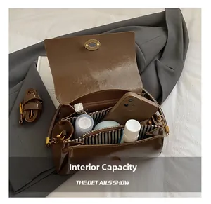 Vue détaillée de l'intérieur du sac en cuir marron avec doublure à rayures et espace