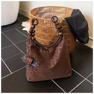 Dettaglio borsa hobo leopardata con manico in perle di legno e portaocchiali retro