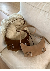 Detail view of retro suede half-moon bags in dark brown and light coffee colors