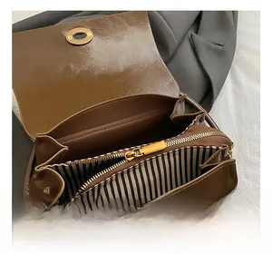 Vue intérieure détaillée d'un sac vintage marron avec finitions dorées et doublure rayée
