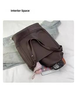 Spacious interior of brown lychee leather tote bag showing items like a tablet and umbrella