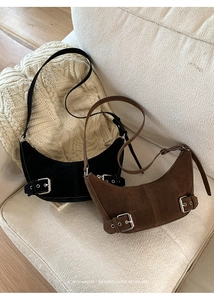 Detail of minimalist crescent crossbody bags in black and brown faux suede finish