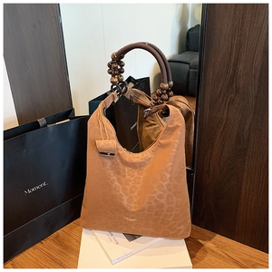 Dettaglio della borsa tote leopardata vintage con manico decorativo in perline di legno