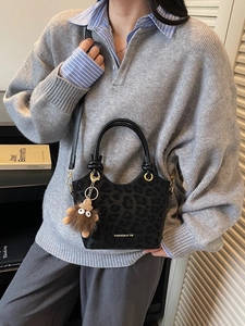 Minimalist black leopard texture bucket bag with knotted handles and plush pendant charm