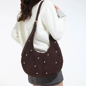 Dettaglio borsa hobo in pelle scamosciata marrone con borchie e tracolla regolabile