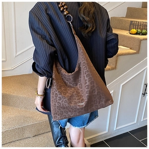 Dettaglio della borsa tote leopardata con tracolla in perline di legno e morbida texture in pelle