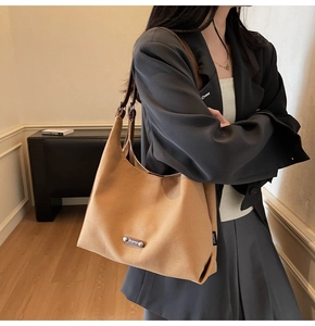 Detail view of khaki canvas hobo bag with dark leather strap on minimalist model