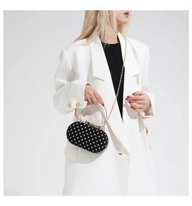 Polka dot handbag with gold bow clasp, metal round handle and elegant chain strap