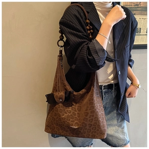 Dettaglio della borsa tote leopardata vintage con tracolla in perline di legno
