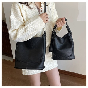 Detail of black pebbled leather texture on crossbody messenger and bucket bags
