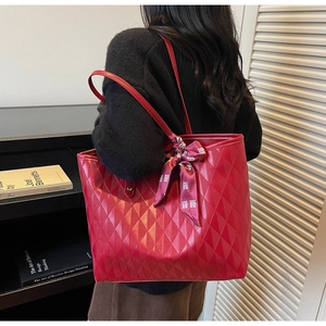 Detail of red quilted tote bag featuring a decorative bow with a traditional double happiness sign