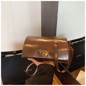 Détail d'un sac bandoulière vintage en cuir huilé marron avec fermoir doré brillant