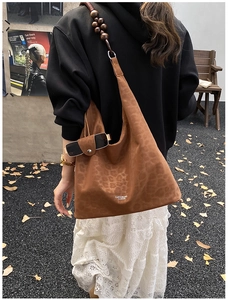 Dettaglio borsa tote vintage in pelle scamosciata maculata con tracolla in perline di legno