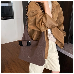 Dettaglio della borsa tote vintage marrone con tracolla in perle di legno e fessura per occhiali