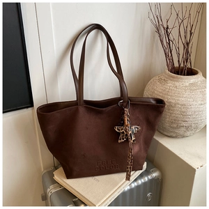 Detail of dark brown suede tote bag with FREE COLOR embossing and leopard star charm