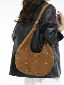 Borsa hobo in camoscio marrone con borchie dorate e tracolla regolabile su modella
