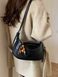 Classic black half-moon hobo bag with vintage wooden bead tassel and elegant leather finish