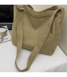 Dettaglio della tracolla regolabile sulla borsa tote in tela kaki in stile workwear