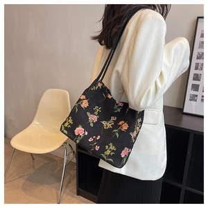 Detail of floral embroidery and quilted texture on black canvas bucket tote bag