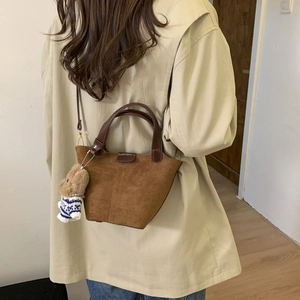 Brown frosted leather bucket bag with cute bear charm shown on model back view