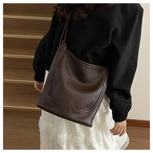 Detail of vintage dark brown tote bag with lychee texture and decorative stitching