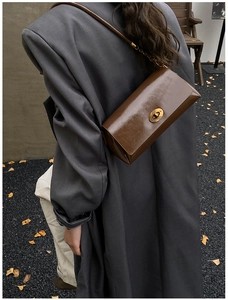 Détail du sac bandoulière vintage marron foncé en similicuir avec fermoir rotatif doré