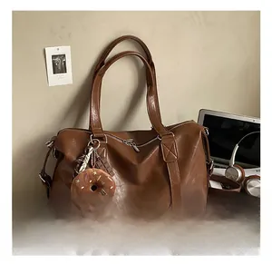 Close-up of brown PU leather tote bag with soft texture and stylish plush donut pendant