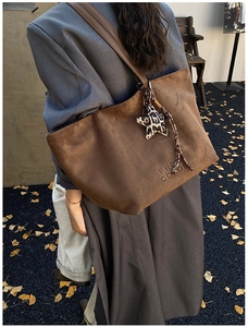 Brown suede tote bag detail with FREE COLOR embossing and leopard star charm accent