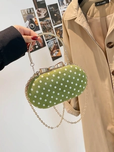 Green polka dot evening bag with gold bow clasp and circular metal handle